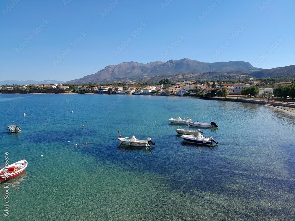 Obraz premium Greek Fishing boards in clear blue water with a blue sky in the background.
