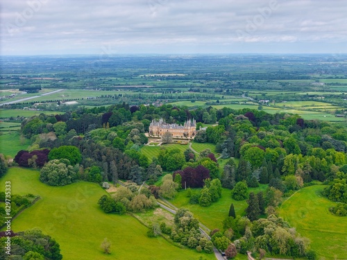 Aerial view of Waddesdon Manor atop a hill surrounded by lush green fields in Buckinghamshire.