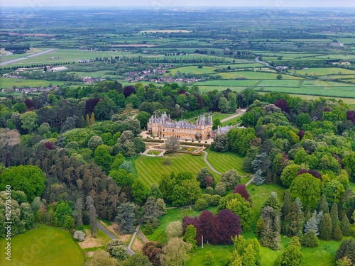 Aerial view of Waddesdon Manor atop a hill surrounded by lush green fields in Buckinghamshire. photo