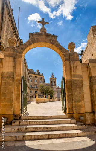 Scenic view through a medieval arched passage reveals the iconic Chapel of St. Mary Magdalene in Pjazza San Pawl Rabat historic core. Cultural heritage of Malta photo