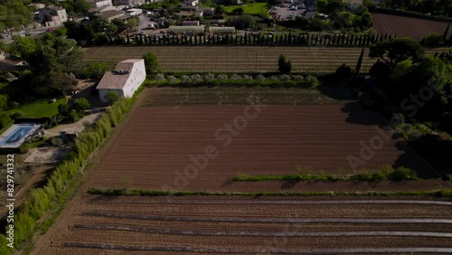 Aerial revealing shot of downtown Pezenas with agricultural fields surrounding photo