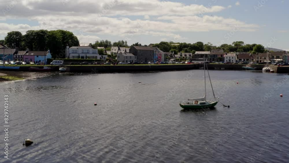 Aerial dolly shot gracefully glides above the water, nearing the town center. Kinvara Aerial dolly shot gracefully glides above the water, nearing the town center. Kinvara