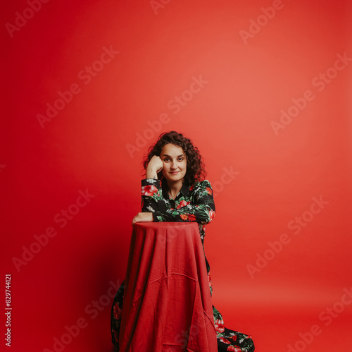 Fashionable woman posing against a vibrant red wall