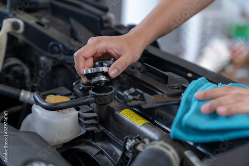 Hands filling water into the car's radiator