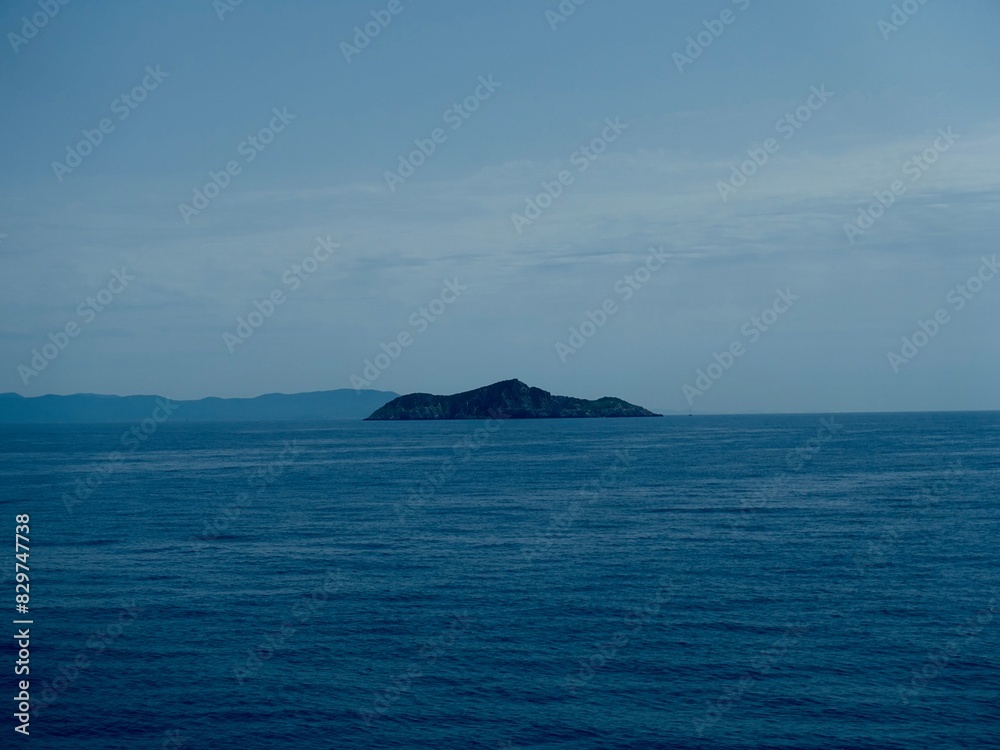 Scenic ocean view with a small island surrounded by blue water Scenic ocean view with a small island surrounded by blue water