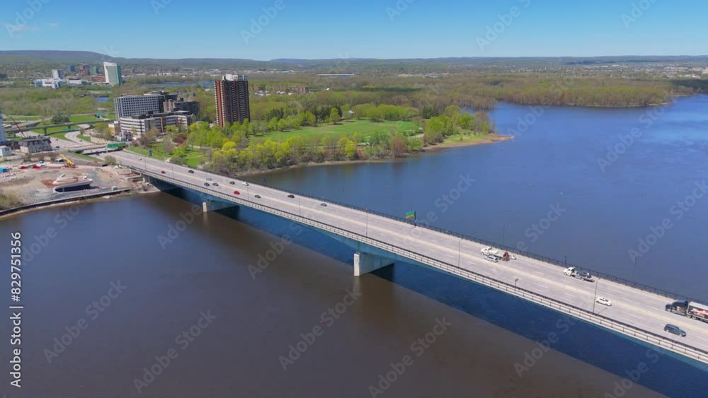 Aerial over coastal bridge with passing vehicles on the Ottawa river at the daytime in Canada Aerial over coastal bridge with passing vehicles on the Ottawa river at the daytime in Canada