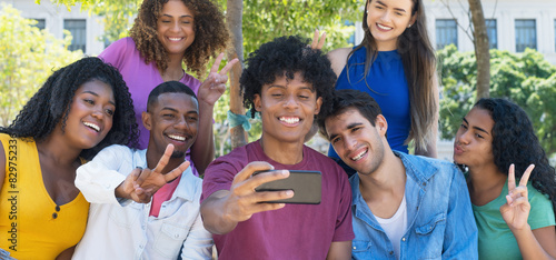 Happy latin american and hispanic and african american and caucasian young adults taking selfie with mobile phone