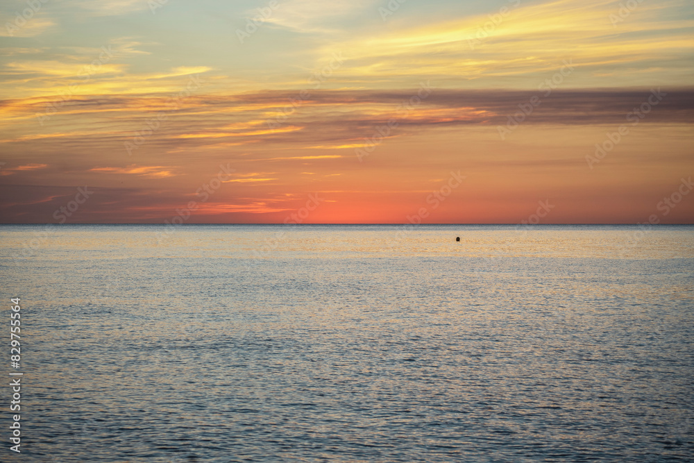 A beach sunrise with clouds in vibrant colors reflecting off the sea, creating a perfect sunset. A beach sunrise with clouds in vibrant colors reflecting off the sea, creating a perfect sunset.