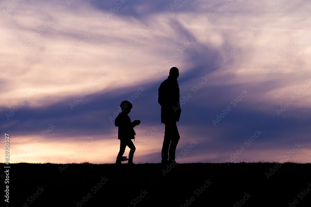 Silhouette of a parent and child against the sky Silhouette of a parent and child against the sky