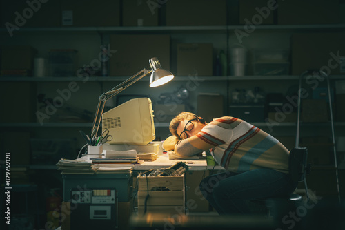 Canvas Print Nerd guy falling asleep at his desk in the garage