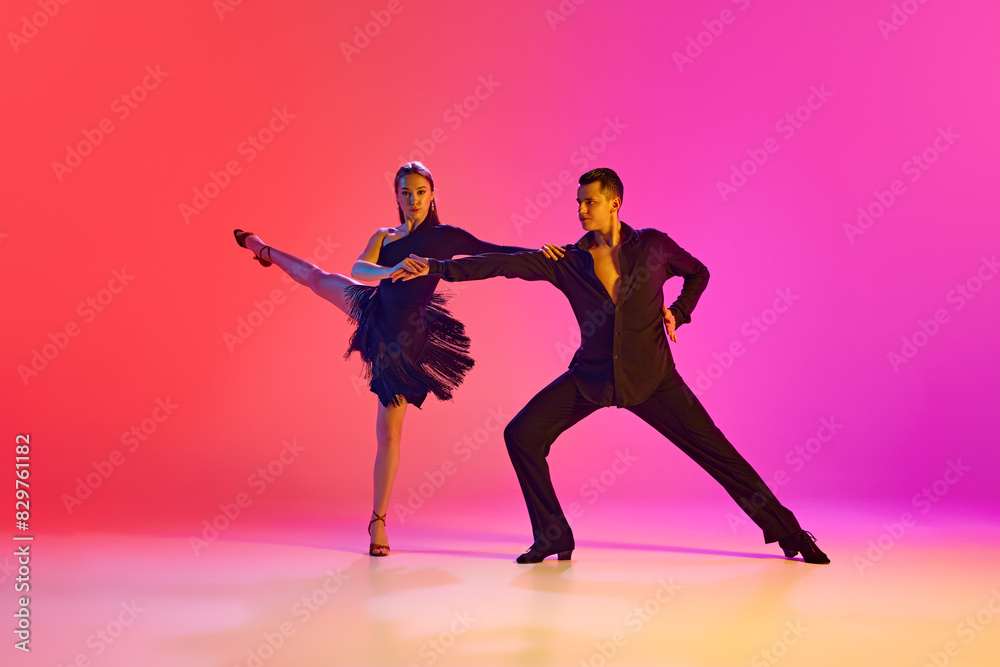 Pair of dancers embody art of ballroom dance, perform their refined movements in neon lighting against vibrant gradient background. Concept of dance and music, sport, action, competition, classical.