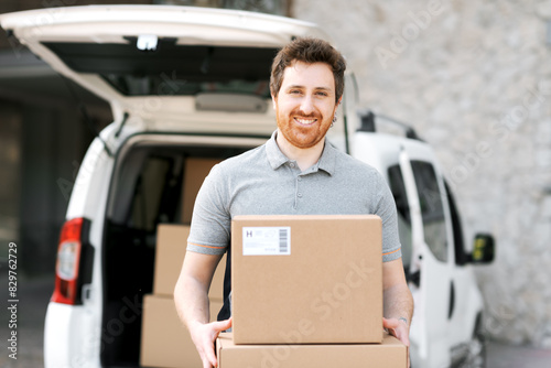 Portrait of a delivery guy carrying boxes © StockPhotoPro