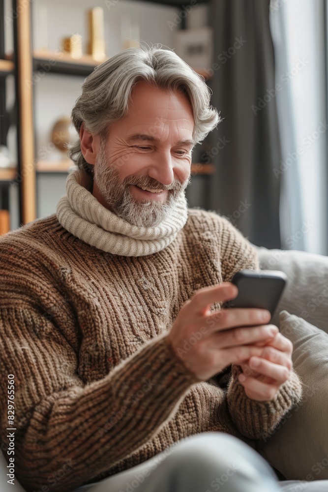 Cheerful man relaxing on sofa at home, happily engaged with smartphone for leisure activities Cheerful man relaxing on sofa at home, happily engaged with smartphone for leisure activities
