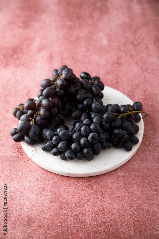 Dark grape on a white desk Dark grape on a white desk