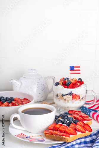 USA patriotic breakfast or brunch with american flag decorated oatmeal  layered yogurt granola dessert  toast sandwiches with fresh berries  and coffee cup on kitchen garden table