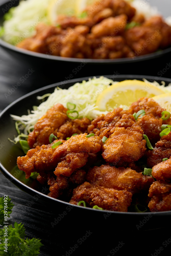 Japanese Fried crispy Chicken Karaage in black bowl with rice and cabbage Japanese Fried crispy Chicken Karaage in black bowl with rice and cabbage