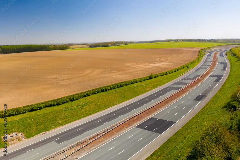 Aerial photo of the M1 motorway located in the city of Leeds in West Yorkshire UK, showing the motorway with no traffic in the spring time with fields at the side