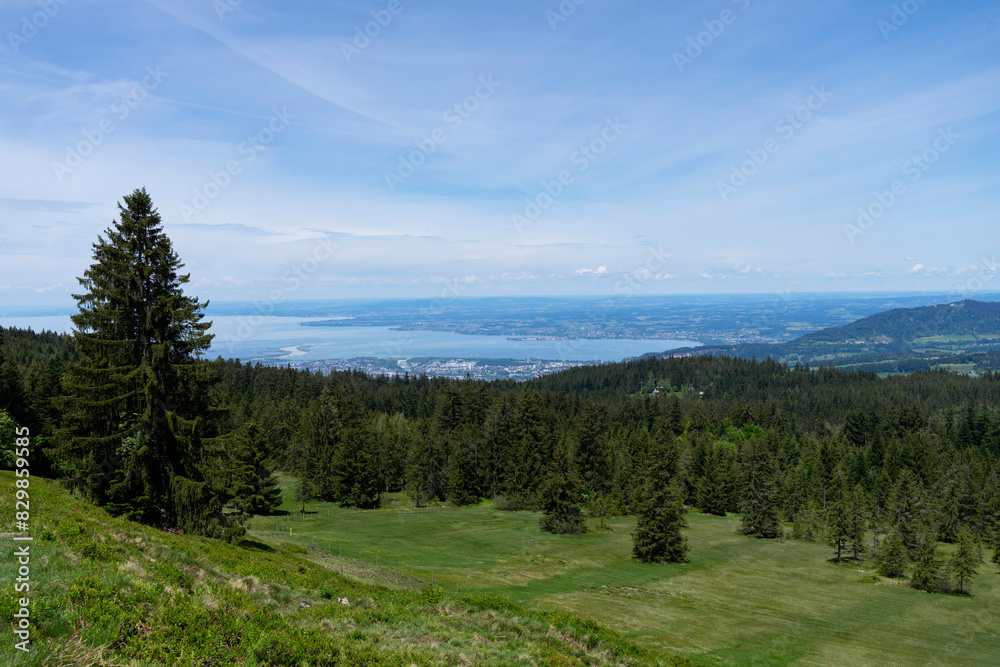 View from high up on a mountain over a forest onto a blue lake and the shore 