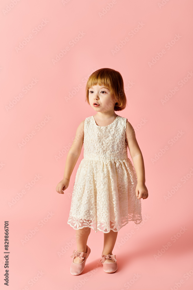 A cute girl in a white dress stands gracefully against a vibrant pink background. A cute girl in a white dress stands gracefully against a vibrant pink background.