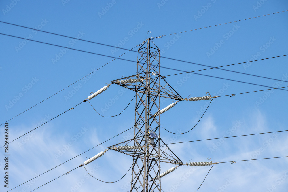 An electric pylon on a beautiful sunny summers day with white fluffy clouds in the sky. An electric pylon on a beautiful sunny summers day with white fluffy clouds in the sky.