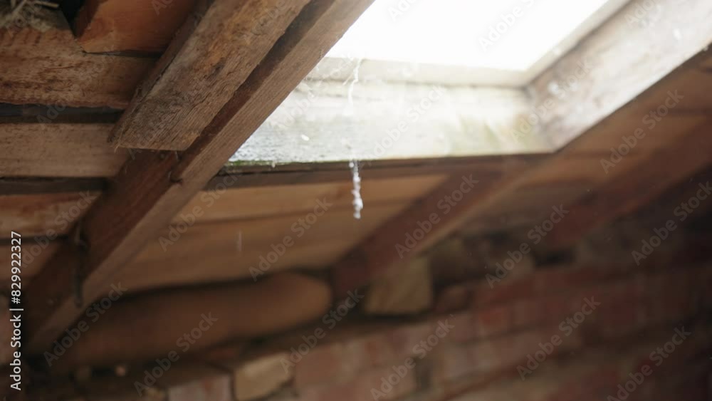 Drops of water fall from attic window. Leak old wooden attic roof. Time for urgent roof repairs Drops of water fall from attic window. Leak old wooden attic roof. Time for urgent roof repairs