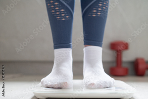 A woman stands on the scale. Legs in socks stands on the scale.