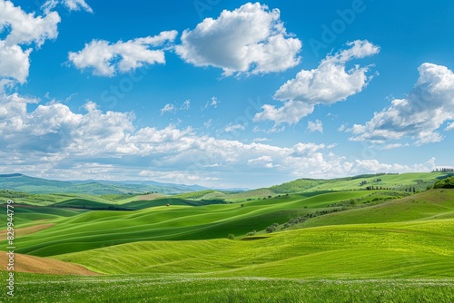 A picturesque view of a serene countryside with rolling green hills under a bright blue sky, capturing the tranquility of rural life © tantawat