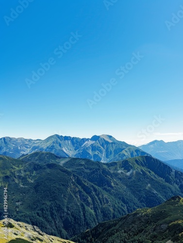 A panoramic view of a mountain range with a clear blue sky, perfect for themes of adventure and natural beauty
