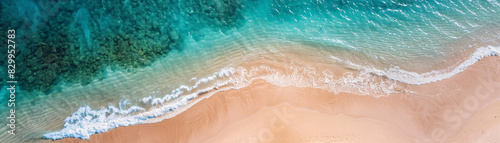 Birds-eye view of an undisturbed sandy beach and clear ocean  filmed during summer  representing perfect leisure in nature. Ocean is calm and the water is blue. Beach is sandy and the waves are small