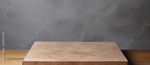 A clean brown pizza box made of paperboard sits on a textured gray stone table The empty box is partially visible offering a large copy space image It captures the essence of home delivery and the sta photo
