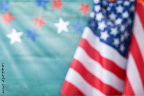 4th of July background. Empty wooden blue plank wall with American USA flag and bokeh lights, sun rays. National Flag Day. Happy Labor, Independence or Presidents Day. Close up with place for text.
