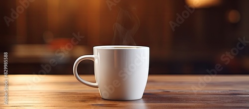 A close up image of a coffee mug is featured on a wooden table providing a copy space for additional content