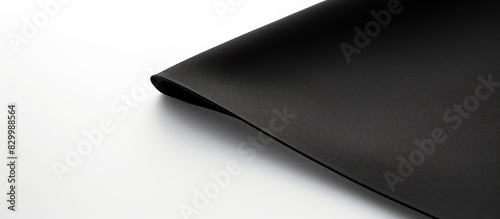 The black corner of a black napkin stands out against a white background with a diagonal line There is plenty of copy space available for text or design on this two toned black and white background
