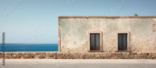 A historic Mediterranean coastal building with an old stone facade offering a beautiful backdrop for a copy space image © vxnaghiyev