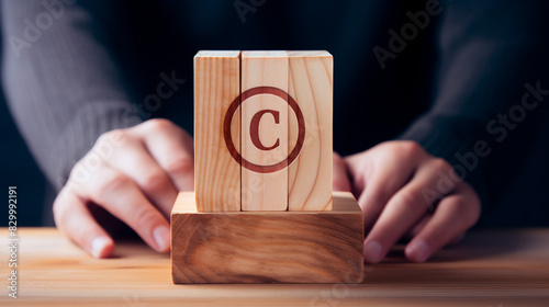 Protecting Intellectual Property: Person Holding Wooden Block with Copyright Icon for Author Rights and Patented Ideas photo