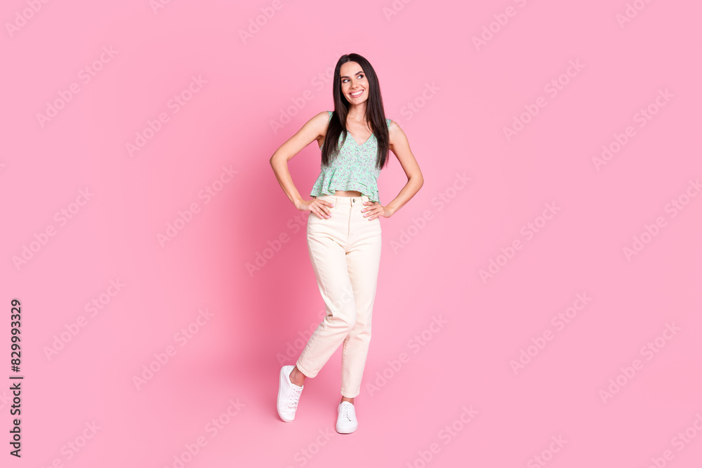 Full length photo of cheerful lovely woman wear stylish clothes look empty space isolated on pink color background Full length photo of cheerful lovely woman wear stylish clothes look empty space isolated on pink color background