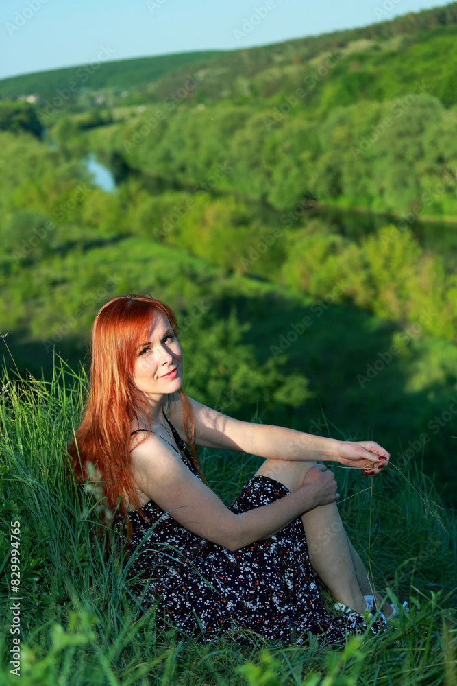 A girl in a red blouse and white jeans poses for the camera in nature. Joy, happiness, serenity. A girl poses for a photographer in nature. A girl in a red blouse and white jeans poses for the camera in nature. Joy, happiness, serenity. A girl poses for a photographer in nature.