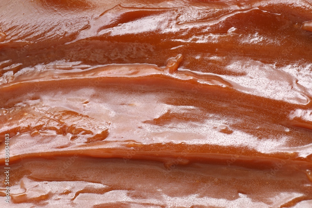 Obraz premium Tasty sweet caramel sauce as background, top view