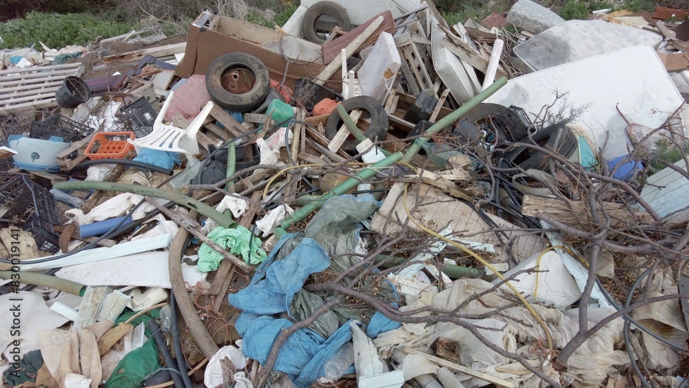 Illegal open-air waste dump in the countryside in Greece - tons of garbage waste, polluting plastics abandoned in nature - environmental sustainability and climate change - full garbage cans