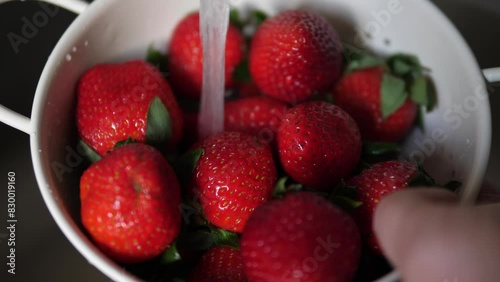 Ripe delicious strawberries under running water