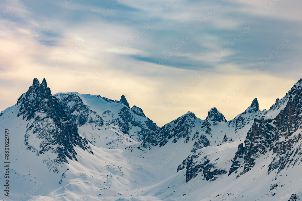 Snow-covered mountain peaks under cloudy sky Snow-covered mountain peaks under cloudy sky