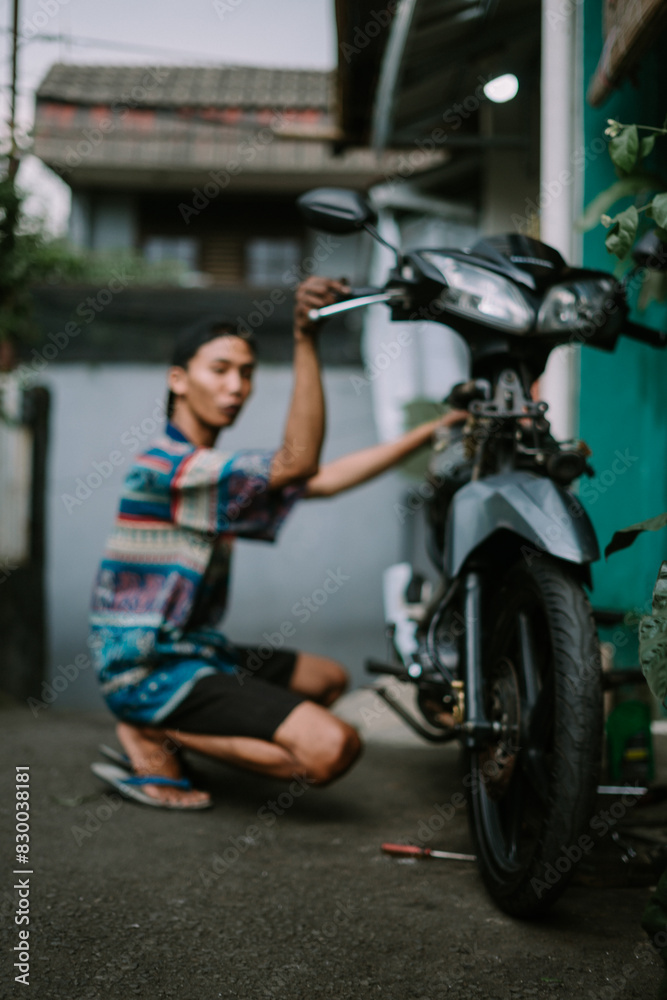 A motorcycle mechanic inspecting a damaged engine A motorcycle mechanic inspecting a damaged engine