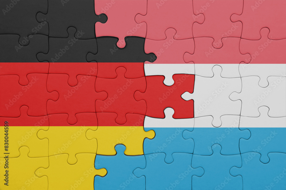 puzzle with the colourful national flag of luxembourg and flag of germany. puzzle with the colourful national flag of luxembourg and flag of germany.
