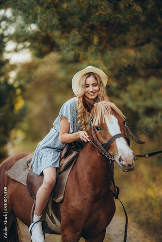 A young beautiful woman rides a horse in the forest in autumn. Horseback riding in the evening in autumn. © sergo321