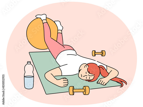 Exhausted woman in fitness room fell asleep on sports yoga mat and needs to rest after workout. Lazy girl sleeps in fitness club, not wanting to do athletics and listen to advice of personal trainer