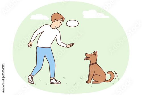 Smiling boy play with dog outdoors
