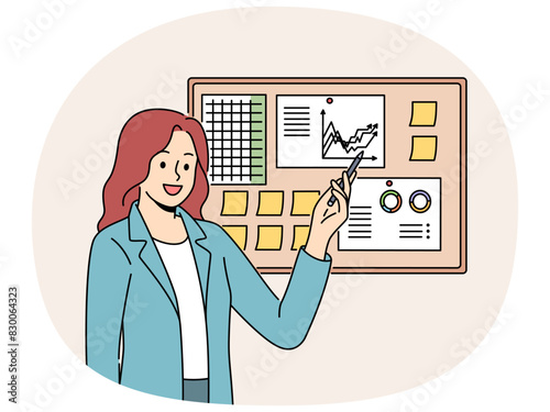 Businesswoman demonstrates financial graphs and charts pinned on cork board in office. Businesswoman boasts about growth of company income and number of clients that bring income to business.