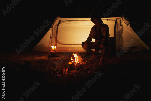 Hikers make a bonfire in front of tent. Campfire, camping concept.