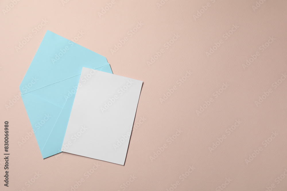 Letter envelope and card on beige background, top view. Space for text Letter envelope and card on beige background, top view. Space for text