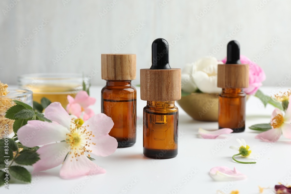 Aromatherapy. Essential oils and flowers on white table, closeup Aromatherapy. Essential oils and flowers on white table, closeup